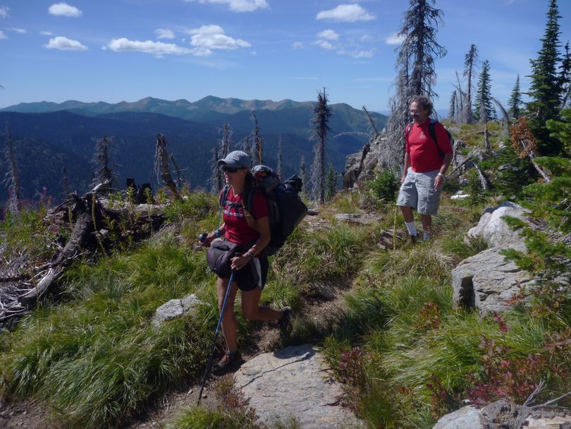 Holly Weiler and Ed Bowers of the Spokane Mountaineers hike down off Little Snowy Top Mountain during a day-long trek on the 20-mile Salmo Loop in the Salmo-Priest Wilderness. In the background is Crowell Ridge and Gypsy Peak, highest point in Eastern Washington.  (Rich Landers)