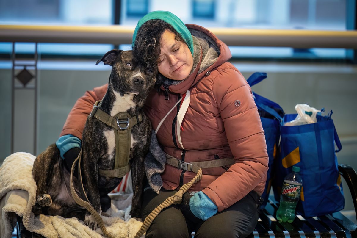 Bobbi Ebel, who has been homeless for four years, gets warm with her dog Syntax in the STA Plaza in January before heading to a shelter. The 2025 point-in-time count shows homelessness is on the decrease in Spokane. (COLIN MULVANY/THE SPOKESMAN-REVIEW)