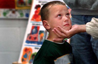 
Ramsey Elementary kindergartner Michael Collins is comforted by his mother and grandmother to ease his first-day jitters. 
 (Kathy Plonka / The Spokesman-Review)