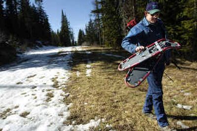 
State water supply specialist Scott Pattee carries his snowshoes off a Mount Spokane cross-country ski trail after a press conference Tuesday morning. 
 (Holly Pickett / The Spokesman-Review)