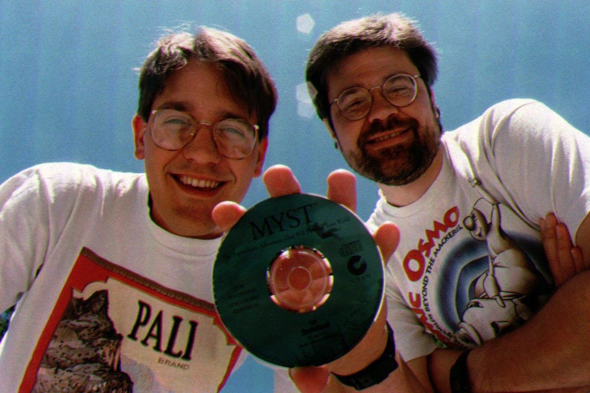 1994 - Robyn Miller, left, holds a copy of the CD-ROM for Myst with his brother, Rand Miller, in Spokane, Wash., July 25, 1994. The Millers are the creators of Myst, a best-selling computer game. (DON MARQUIS / Associated Press)