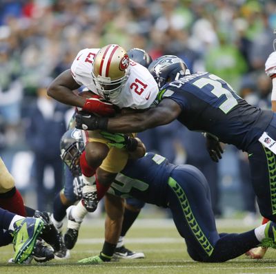 San Francisco 49ers' Frank Gore  is tackled by strong safety Kam Chancellor in the first half of Sunday's game that was dominated by the Seahawks.
 (John Froschauer / Fr74207 Ap)
