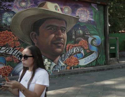 A woman stands near a mural depicting late Mayor Carlos Manzo, who was killed during a Day of the Dead event, in Uruapan, Mexico, November 7, 2025. REUTERS/Ivan Arias  (Ivan Arias)