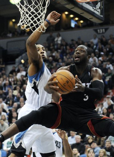 Miami’s Dwyane Wade lays one up as Derrick Williams of the Timberwolves defends in the second half. Wade scored 19 points. (Associated Press)