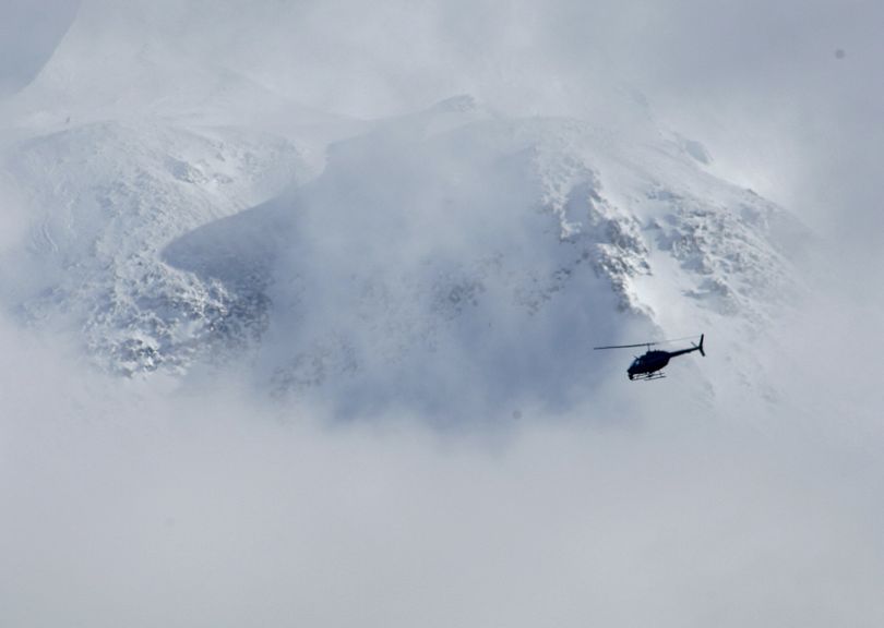 A helicopter flies past the crater of Mount St. Helens Tuesday afternoon, Feb. 16, 2010, during the search for a climber who fell 1,500 feet into the dormant crater of the volcano Monday in Washington state. (Ted Warren / Associated Press)