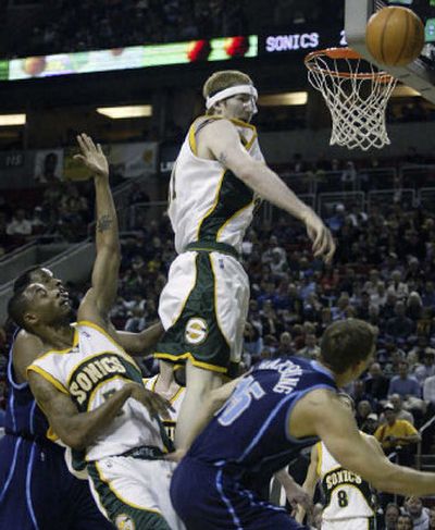 
Sonics center Robert Swift leaps to block a shot by Utah's Matt Harpring. 
 (Associated Press / The Spokesman-Review)