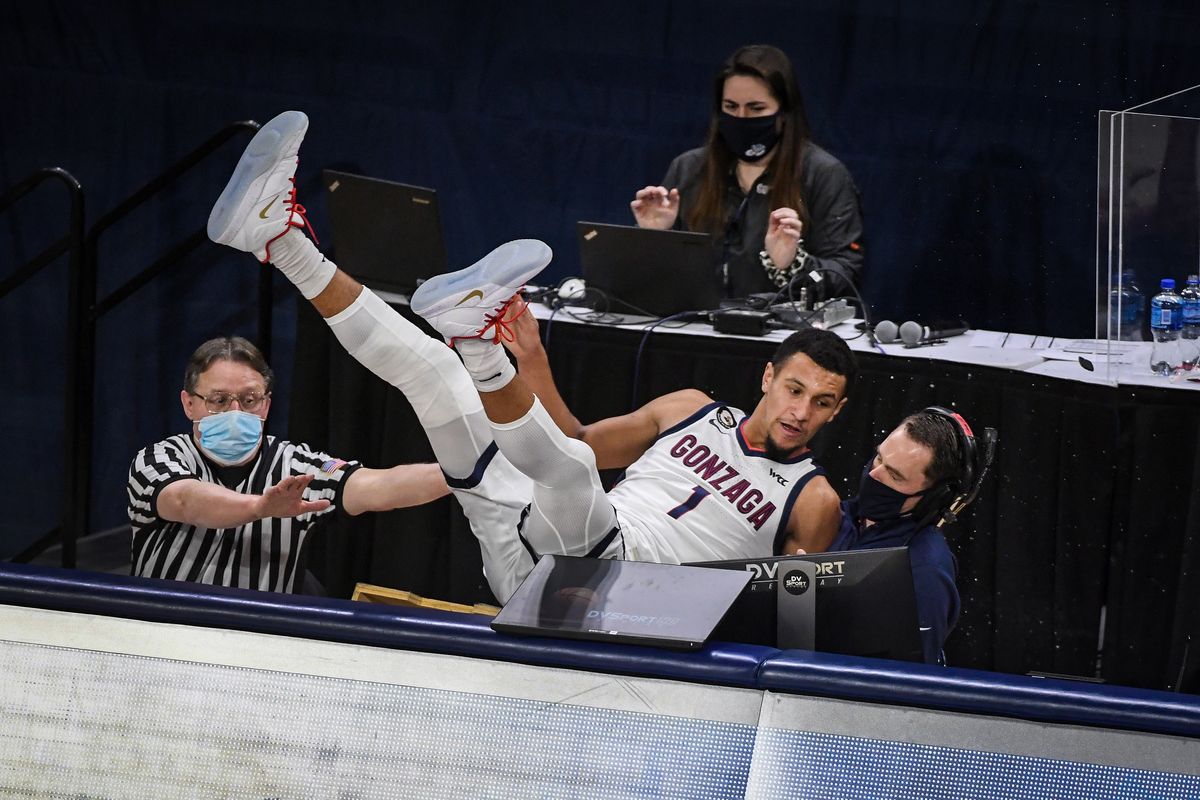 Gonzaga guard Jalen Suggs falls into the scorers table Saturday after trying to save a ball from going out of bounds.  (Colin Mulvany/THE SPOKESMAN-REVIEW)