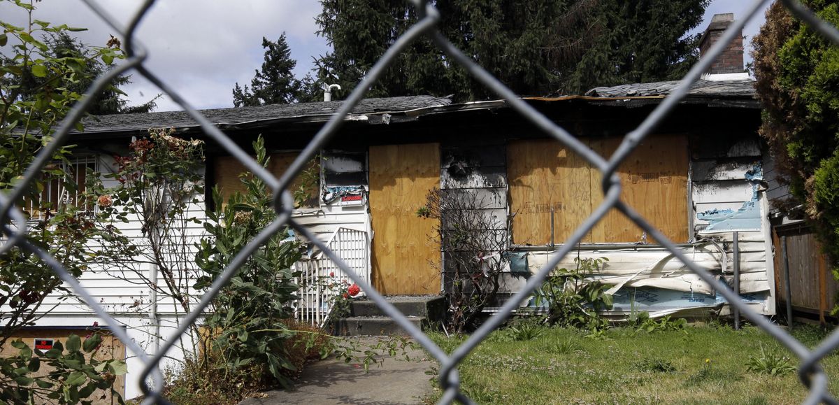 A fire-damaged, abandoned and boarded-up house stands in Portland, Ore., Tuesday, June 14, 2016. City officials in this booming Pacific Northwest metropolis have developed a plan to foreclose on so-called “zombie homes” for first time in 50 years as Portland grapples with a swelling population and skyrocketing home costs that threaten to lock new homeowners out of the market. (Don Ryan / Associated Press)