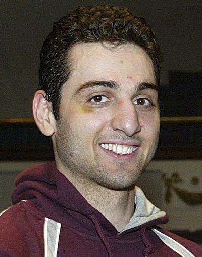 In this Feb. 17, 2010, photo, Tamerlan Tsarnaev, smiles after accepting the trophy for winning the 2010 New England Golden Gloves Championship in Lowell, Mass. Tsarnaev, 26, who had been known to the FBI as Suspect No. 1 in the Boston Marathon Explosions and was seen in surveillance footage in a black baseball cap, was killed overnight on Friday, April 19, 2013, officials said. (Julia Malakie / The Sun of Lowell)