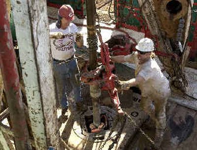 
Workers add a section of drilling pipe as they search for oil on a drilling rig owned by Sterling Oil near Zenda, Kan., last month.Record high oil prices have created renewed interest in domestic oil drilling, but drillers are having some difficulty finding workers for new rigs. 
 (Associated Press / The Spokesman-Review)