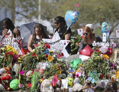 In this Feb. 25, 2018  photo, mourners bring flowers as they pay tribute at a memorial for the victims of the shooting at Marjory Stoneman Douglas High School, in Parkland, Fla. (David Santiago / associated press)