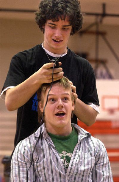 
Steven Clark, 17, shaves a chunk of hair off Ryan Staley, 17, during a Thursday morning assembly  at West Valley High in Spokane Valley. Staley agreed to lose his hair to raise money for the Make-A-Wish Foundation. Going bald will help Staley transform into Dr. Evil for the Golden Throne basketball game with East Valley High.
 (Liz Kishimoto / The Spokesman-Review)