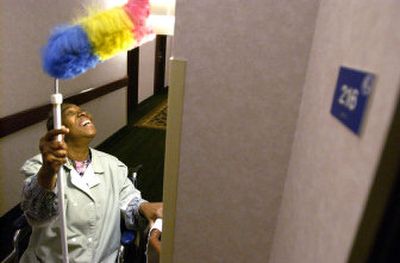 
Verdia Davis dusts a lamp from her wheelchair at the Best Western Pheasant Hill, where she has worked for about six months. Davis found the job with the help of Skils'kin, a Spokane organization that helps people with disabilities find work.
 (Joe Barrentine / The Spokesman-Review)