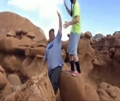 This frame grab from a video taken by Dave Hall shows two men cheering after an ancient rock formation at Utah’s Goblin Valley State Park was knocked over. (Associated Press)