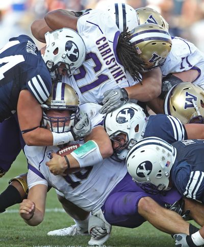 BYU’s Brandon Ogletree, left, sacks Washington quarterback Jake Locker. (Associated Press)