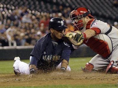 Ronny Cedeno is tagged out by Mike Napoli in the second inning.  (Associated Press / The Spokesman-Review)