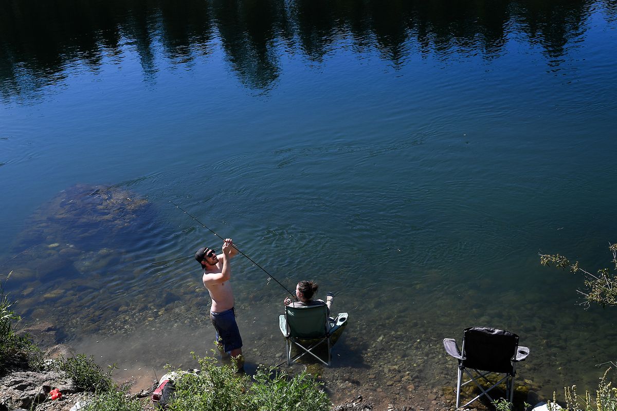 Max Orranita prepares a hook and rod for his girlfriend Jamie Warpenburg as they take to the waters of the Spokane River to cool off on July 6, 2020, at Riverside State Park.  (Tyler Tjomsland/THE SPOKESMAN-RE)