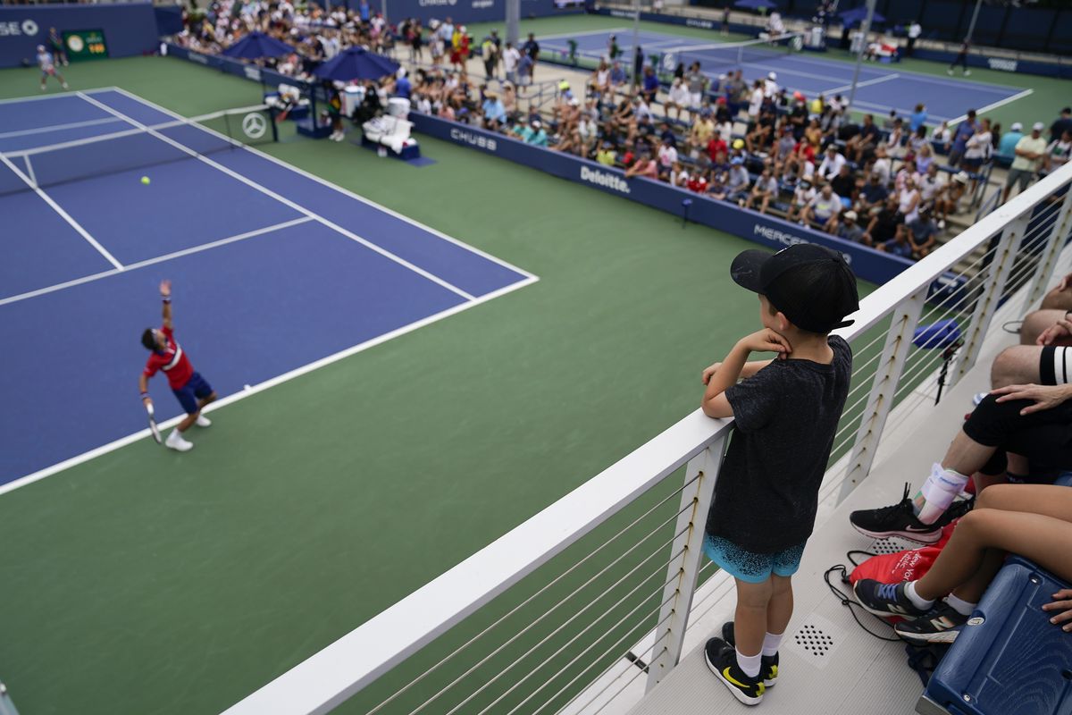 Tennis fans watch as Ricardas Berankis, of Lithuania, serves to Diego Schwartzman, of Argentina, during the first round of the US Open tennis championships, Monday, Aug. 30, 2021, in New York.  (John Minchillo)
