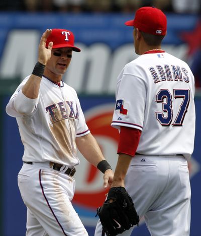 Texas Rangers' Michael Young, left, and Mike Adams (37) congratulate each other following their baseball game against the Seattle Mariners, Thursday, in Arlington, Texas. Young hit a two-run home run and had four RBIs to back Derek Holland, leading the Rangers over the Mariners 5-3.   (Associated Press)