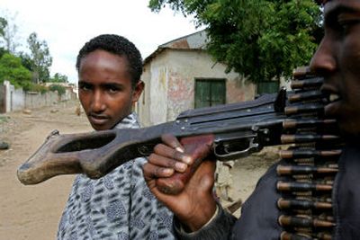 
A young man looks over the weapon carried by a militiaman of the Islamic Courts Union on Saturday in Balad, about 40 kilometers north of Mogadishu, the Somali capital. 
 (Associated Press / The Spokesman-Review)