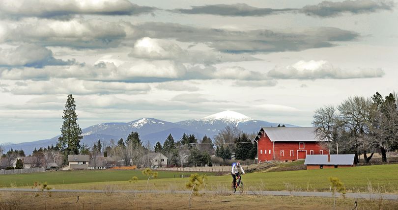Early-spring cycling. Lauri Costello fights a stiff breeze as she rides her bike on a trail that follows the old Ben Burr railroad line en route to Tower Mountain on Thursday. (Christopher Anderson)