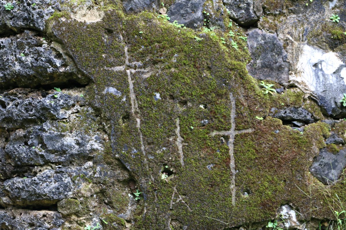 This undated photo, provided by the Hawaii Department of Land and Natural Resources, shows crosses etched by vandals on the crumbling remains of the 180-year-old summer palace of former King Kamehameha III in the forest of a Honolulu, Hawaii, neighborhood. (Hawaii Department of Land and Natural Resources via Associated Press)