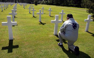 
U.S. citizen Robert Antuono kneels in front of the grave of his brother-in-law Edward Di Falco at the U.S. military cemetery of Colleville-sur-Mer, France, on Tuesday, the 62nd anniversary of D-Day. 
 (Associated Press / The Spokesman-Review)