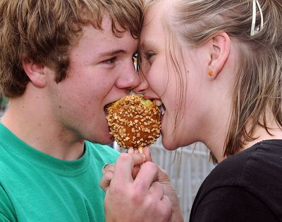 ORG XMIT: OKENI101 Jordan Wilson, left, and Hannah Conyers share a caramel apple at the Ottaway Amusement Company Carnival during the 77th Annual Tri-State Music Festival Sunday, May 3, 2009 in Enid, Okla. (AP Photo/Enid News and Eagle, Bonnie Vculek) (Bonnie Vculek / The Spokesman-Review)