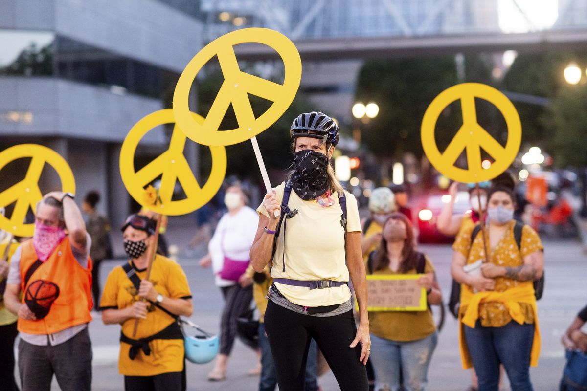 Mary Hubert, part of a "wall of moms," holds a peace sign during a Black Lives Matter rally on Wednesday, July 22, 2020, in Portland, Ore.  (Noah Berger)