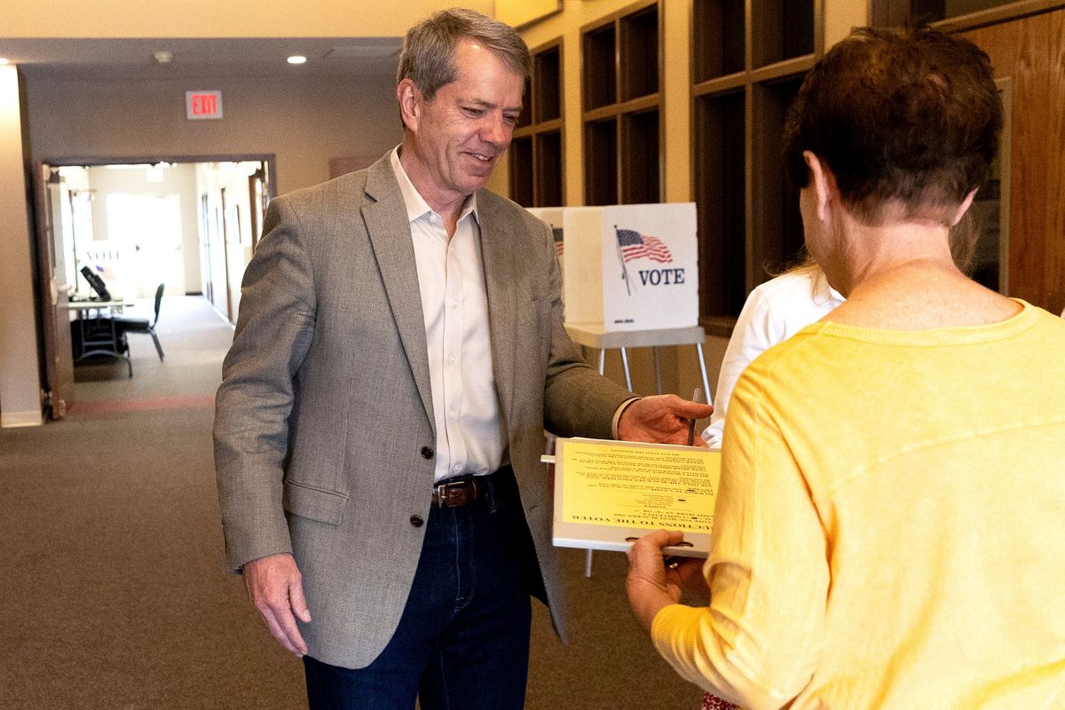 Jim Pillen turns his ballot into Linda Paitz at his polling place, Columbus Berean Church, in Columbus, Nebraska, on Tuesday, May 10, 2022.  (Eileen T. Meslar)