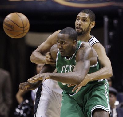 Spurs’ Tim Duncan, right, knocks the ball away from Boston Celtics’ Kendrick Perkins during Thursday night’s game.  (Associated Press)