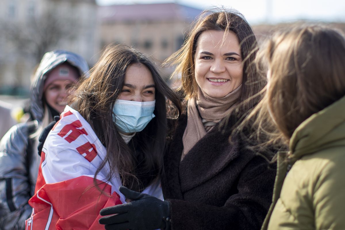 In this Saturday, March 20, 2021 photo, Belarus opposition leader Sviatlana Tsikhanouskaya, right, poses for photos with demonstrators during a protest demanding freedom for political prisoners in Belarus at the Cathedral Square in Vilnius, Lithuania. Belarus authorities on Monday March 29, 2021, announced a criminal probe against Sviatlana Tsikhanouskaya, the nation