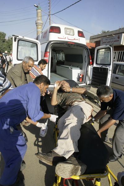 An injured man is transported to Ibn al-Nafees hospital after a bomb exploded Monday in Baghdad.  (Associated Press / The Spokesman-Review)