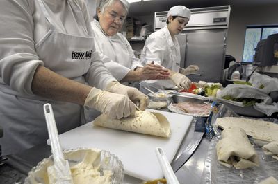 Chef instructor Vira Melendez-Redman, center, works with trainees including Keri Perdue, right, as they learn to make wraps Thursday. Trainees learn organization, food handling, time management, sanitation and other skills through the Transitions program at New Leaf Bakery and Café. (CHRISTOPHER ANDERSON / The Spokesman-Review)