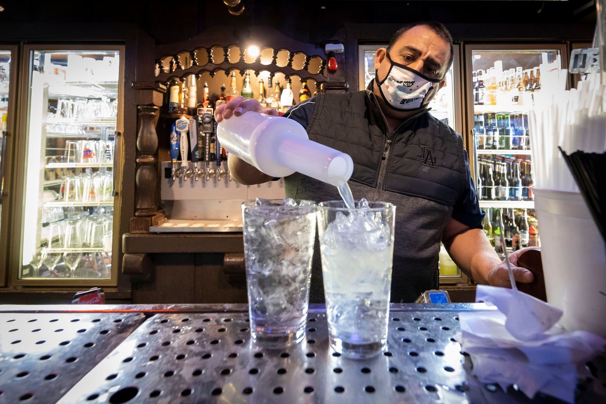 Swinging Doors bartender Rudy Gutierrez makes a Long Island iced tea for a customer Tuesday. The omicron surge has once again sparked major problems for the hospitality industry. Sen. Maria Cantwell talked to restaurant owners about that Tuesday.  (Colin Mulvany/THE SPOKESMAN-REVIEW)