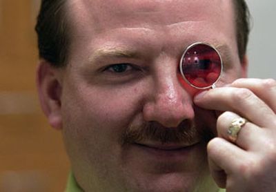 
Optometrist Larry Breazeal holds up a magenta filter that he uses to correct colorblindness.
 (Liz Kishimoto / The Spokesman Review / The Spokesman-Review)