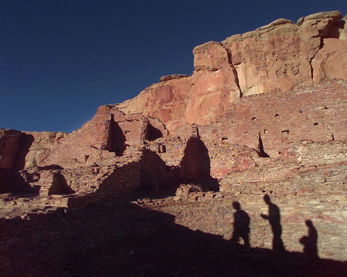 this Nov. 21, 1996, file photo, tourists cast their shadows on the ancient Anasazi ruins of Chaco Canyon in N.M. Research suggests three archaeological sites in the Southwest: Chaco Canyon, Aztec Ruins and Casas Grandes represent three successive stages of the same political regime. Native American leaders are banding together to pressure U.S. officials to ban oil and gas exploration around a sacred tribal site that features massive stone structures and other remnants of an ancient civilization. Tribes are gathering Thursday, March 21, 2019, to face the Trump administration’s pro-drilling stance as they push for further protections surrounding Chaco Culture National Historical Park. (Eric Draper / Associated Press)