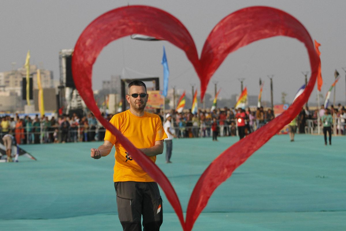 A kite flyer from Switzerland flies his heart shaped kite during international kite festival in Ahmadabad, India, Monday, Jan. 11, 2016.The event is scheduled to run till Thursday.