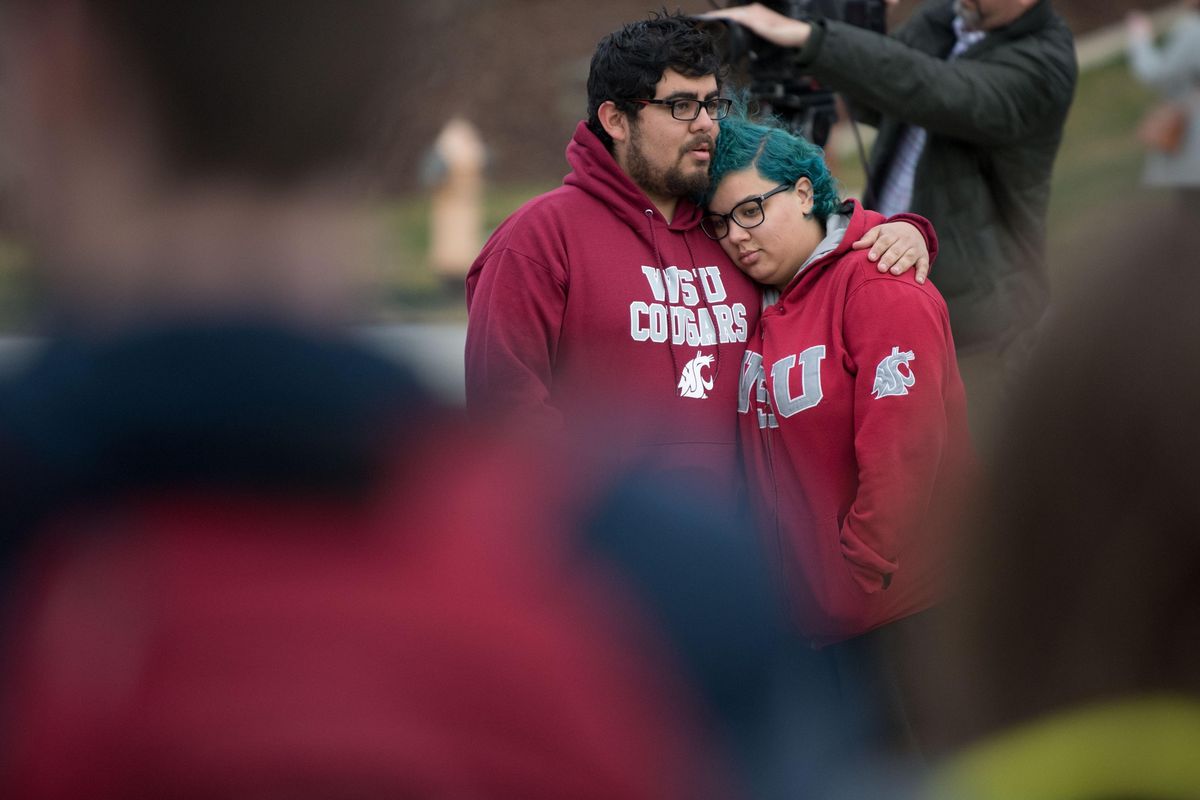 Marching Band members Rick Flores, left and Amber Yiust embrace in grief over the loss of WSU quarterback Tyler Hilinski during a brief memorial held on Wednesday, Jan. 17, 2018, near the Cougar Pride statue outside Martin Stadium in Pullman, Wash. (Tyler Tjomsland / The Spokesman-Review)