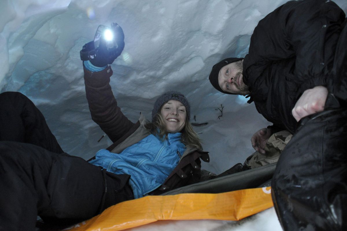Lexi Nelson and Shannon Lavada check out the newly carved snow cave they built near Lookout Pass during an overnight snowshoeing trek with the Spokane Mountaineers. (Rich Landers/The Spokesman-Review)