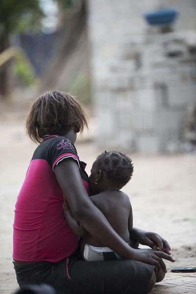 In this photo taken  Nov. 19, a 17-year-old mother sits with her baby in the Inhassune village, near Inhambane, southern Mozambique. In Mozambique there are no laws preventing child marriages, and existing child protection laws offer loopholes.