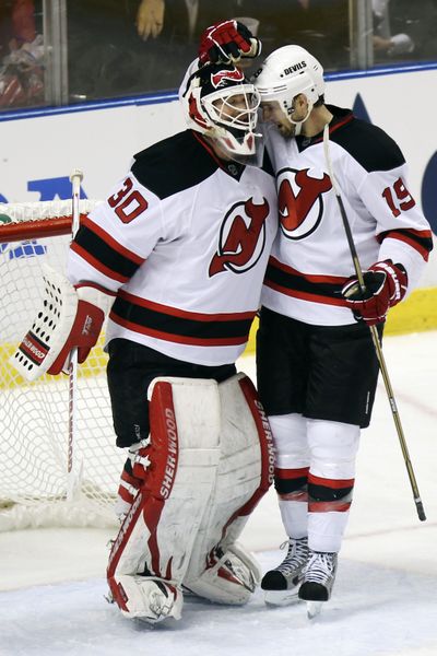 New Jersey Devils goalie Martin Brodeur and Travis Zojac celebrate their 3-2 win over the Florida Panthers in playoff opener. (Associated Press)