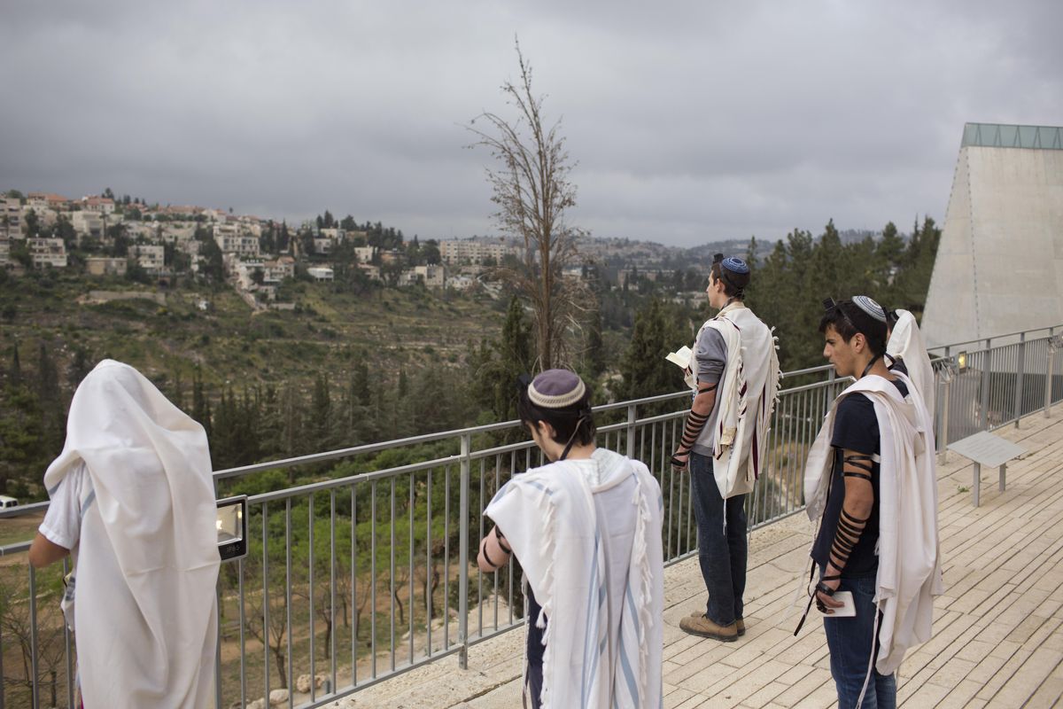 Visitors pray before their tour at the Yad Vashem Holocaust Memorial in Jerusalem, Sunday, April 23, 2017. Israel is marking the annual Holocaust Remembrance Day beginning at sunset Sunday. (Oded Balilty / Associated Press)