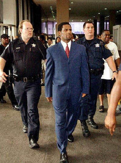 
Singer R. Kelly seen with officials as he arrives for a court appearance on June 26, 2002. 
 (File Associated Press / The Spokesman-Review)