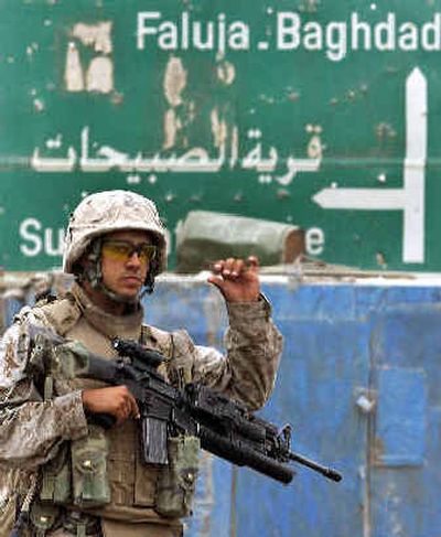 
A U.S. Marine gestures during a patrol outside Fallujah on Sunday. American forces are preparing for a major assault on the rebel-held city. 
 (Associated Press / The Spokesman-Review)