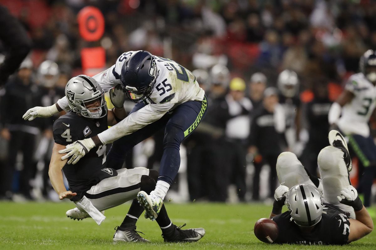 Oakland Raiders quarterback Derek Carr  is sacked by Seattle Seahawks defensive end Frank Clark  during the second half of a game at Wembley Stadium in London on  Oct. 14. (Matt Dunham / AP)