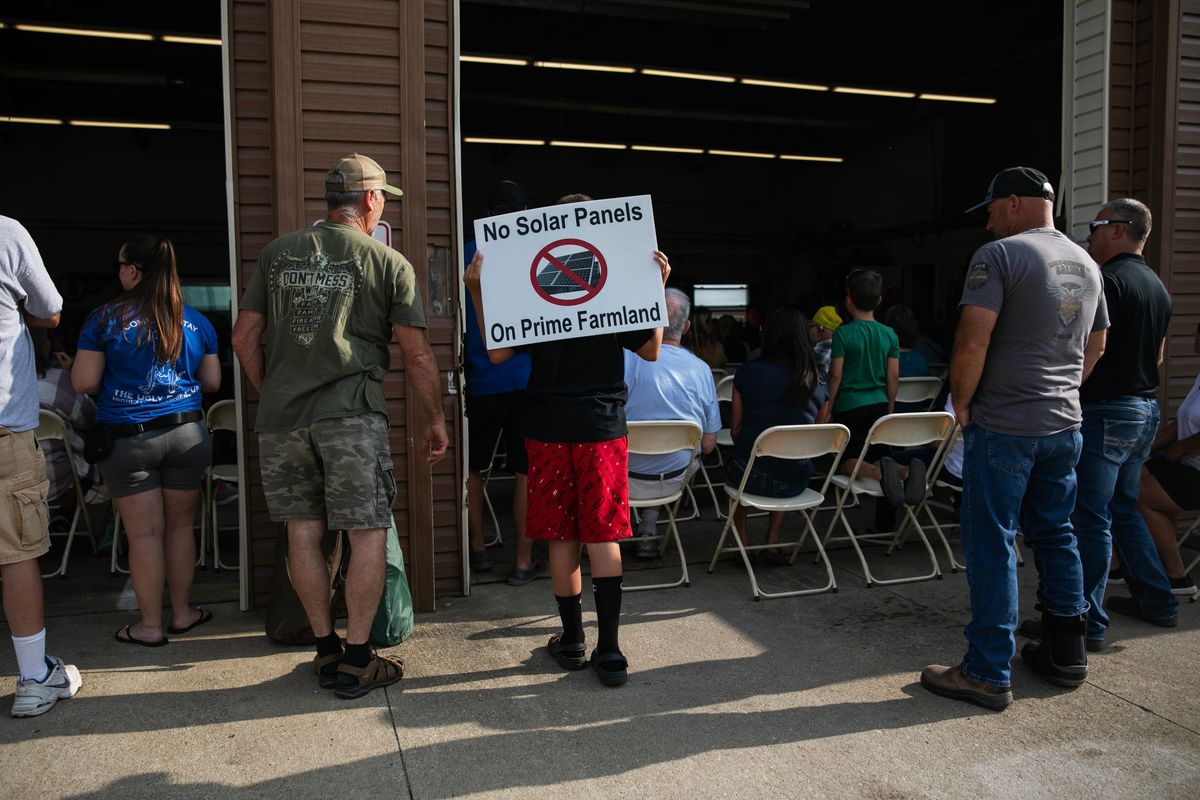 People hold “No Solar on Prime Farmland” signs at a zoning meeting in Millersport, Ohio, on July 19.  (Maddie McGarvey/For The Washington Post)