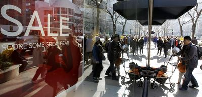 Shoppers are reflected as they enter the Nike Store on Chicago’s Magnificent Mile on Saturday.  (Associated Press / The Spokesman-Review)
