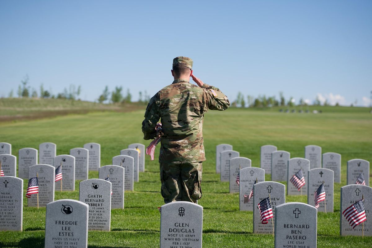 Spc. Robinson of the Washington National Guard Honor guard salutes graves after placing flags on Friday, May 26, 2017, at Washington State Veterans Cemetery in Medical Lake, Wash. (Tyler Tjomsland / The Spokesman-Review)