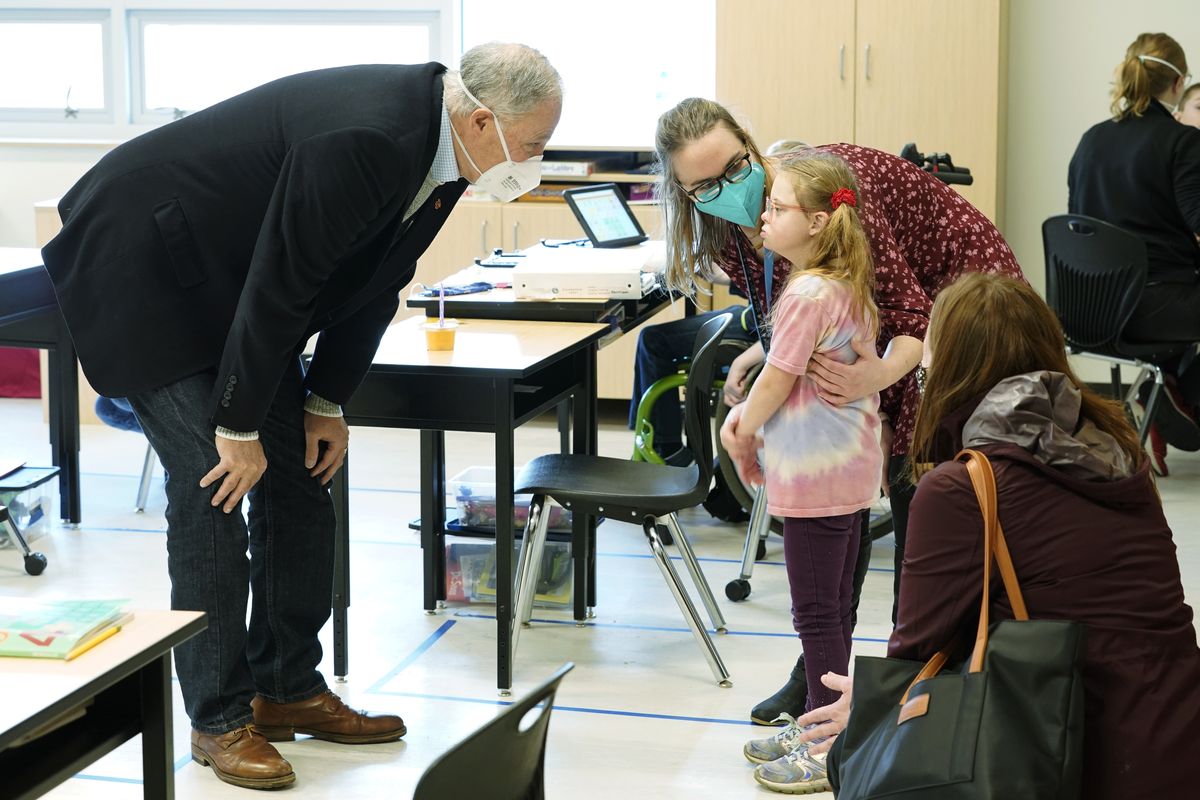 Washington Gov. Jay Inslee, left, talks with a student as teacher Alyson Lykken, center, looks on on Feb. 2 during a visit to a low-incidence disability classroom at Elk Ridge Elementary School in Buckley, Wash.  (Ted S. Warren)